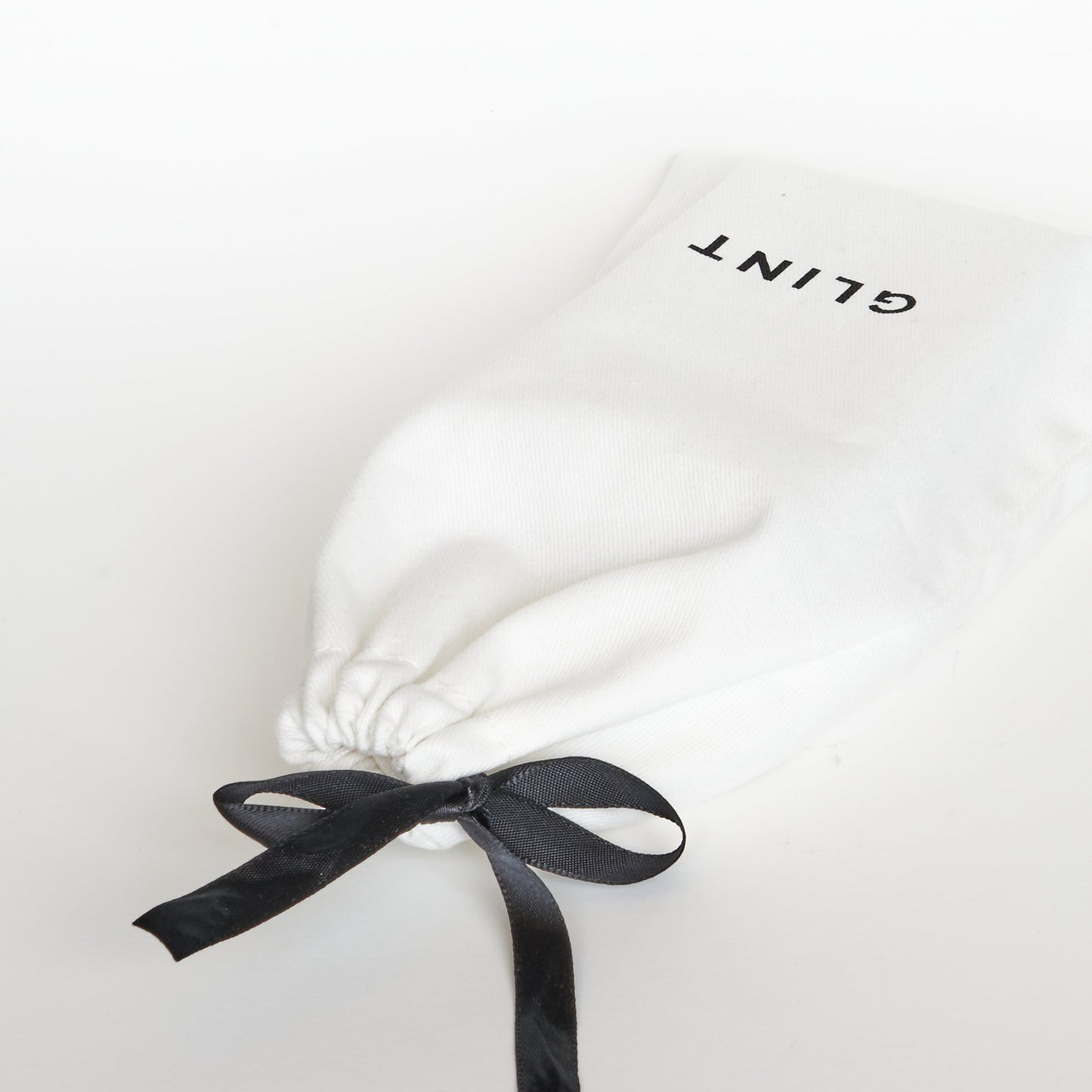 White Drawstring bag with glint logo screenprinted on it. This comes free with your purchase.