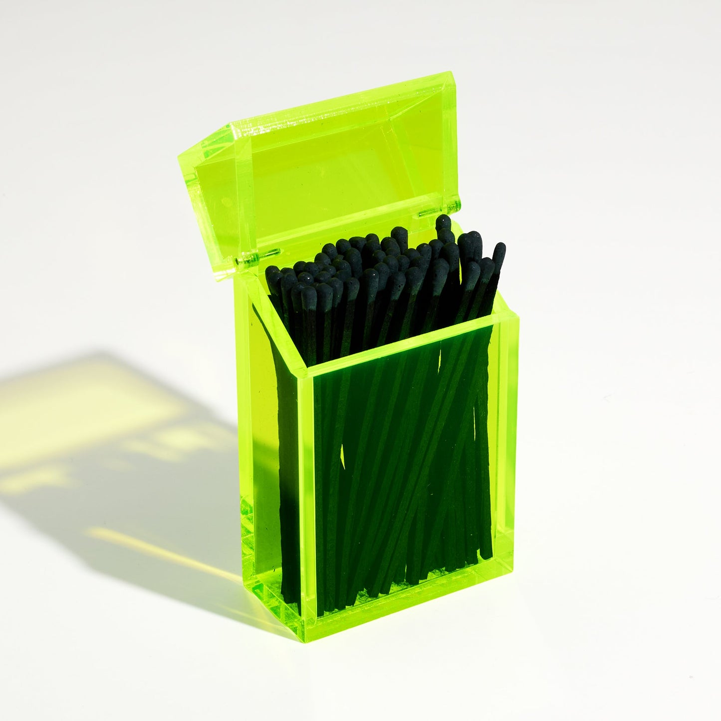 Opened Opened Match holder shaped like a Cigarette Case. Made with neon green acrylic. Case holds Black matches in it.