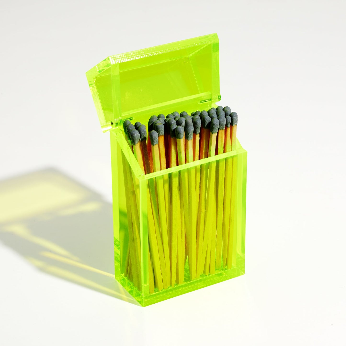 Opened Opened Match holder shaped like a Cigarette Case. Made with neon green acrylic. Case holds Gray matches in it.