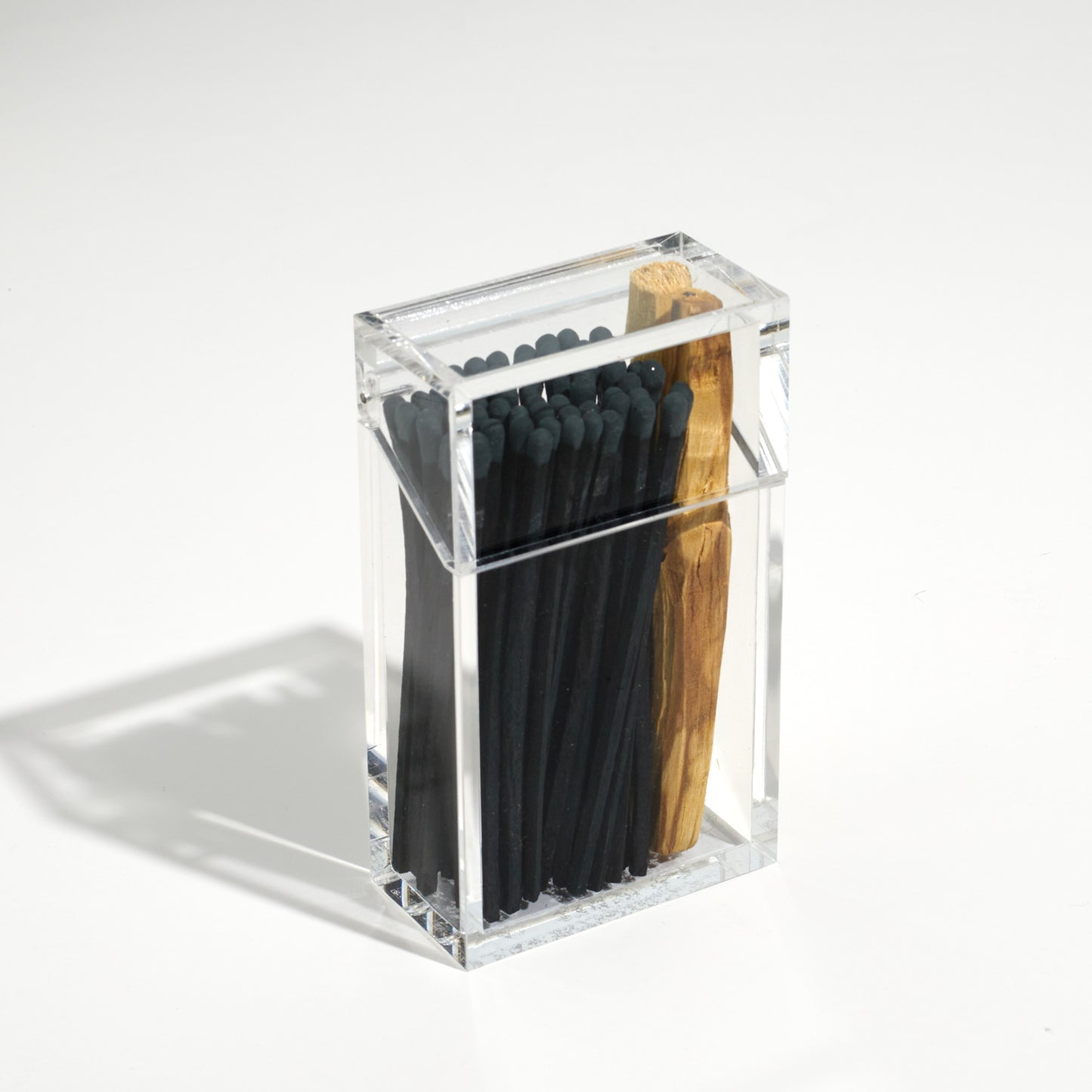 Closed Cigarette style acrylic case with Black matches and palo santo in it. 