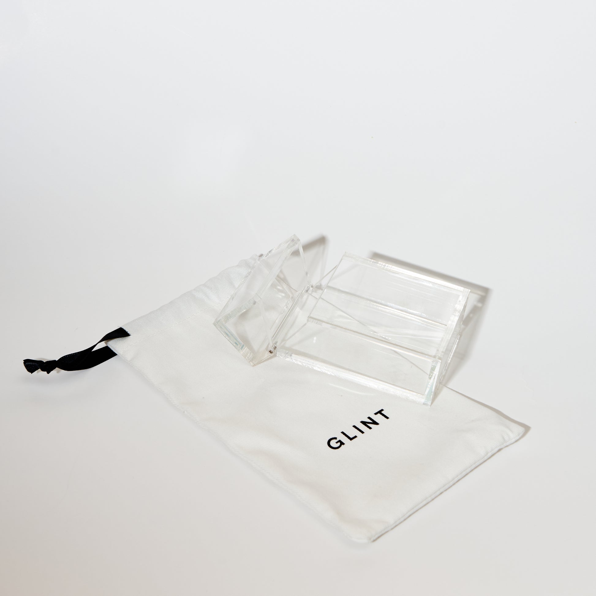 ACRYLIC CIGARETTE CASE LAYING ON A GLINT BRANDED DRAWSTRING CANVAS BAG